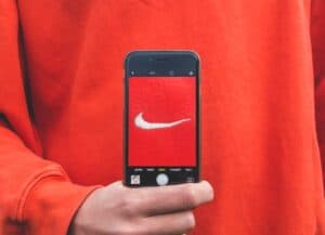 person holding phone with Nike logo on the screen